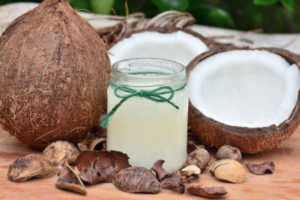 coconut oil in glass jar with coconuts