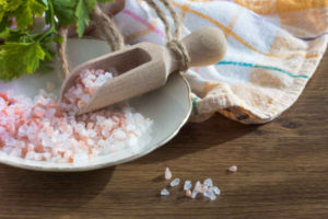 pink salt on plate with wooden scooper